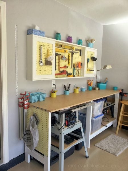 DIY tutorial to build a workbench and pegboard tool cabinet with sliding doors, featured on Remodelaholic.com