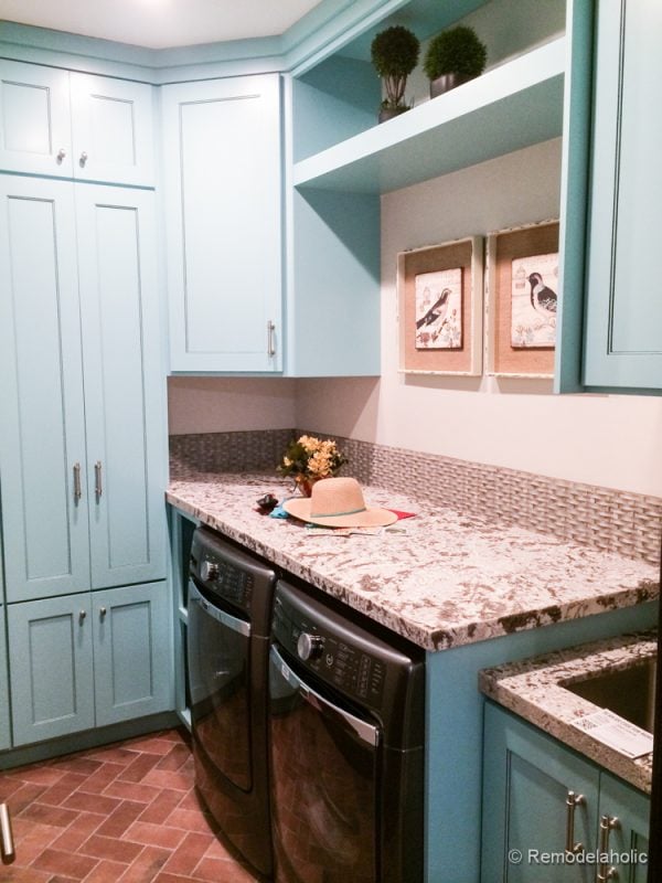 Blue cabinets and brick floor for a unique laundry area. Fabulous Laundry room design ideas from @Remodelaholic
